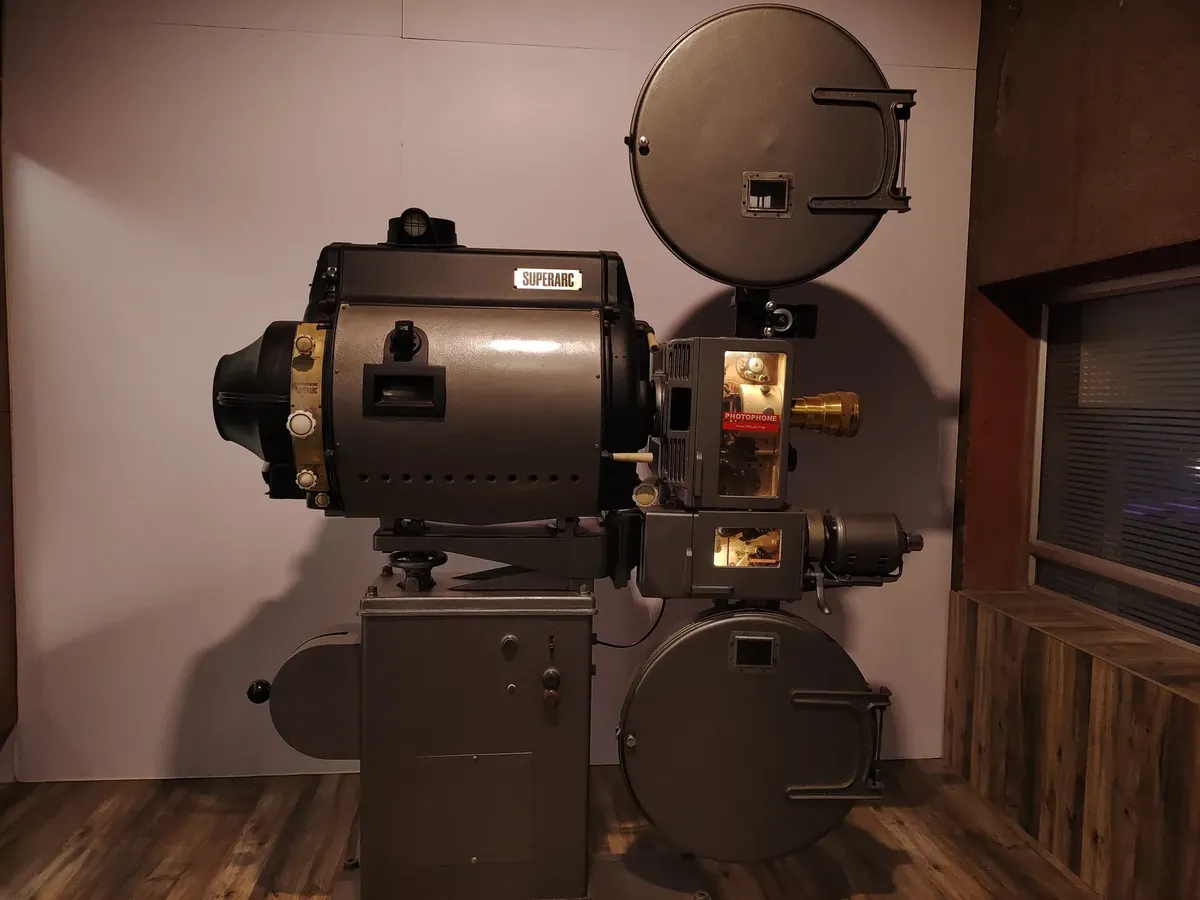 Old-fashioned Superarc film projector displayed indoors, evoking cinematic history.