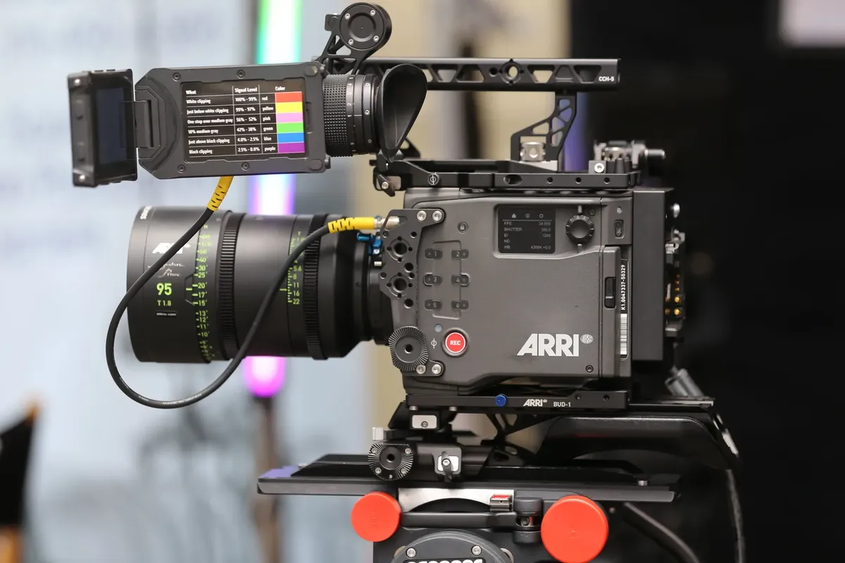 Close-up of a sophisticated professional video camera with a large lens and a viewfinder.