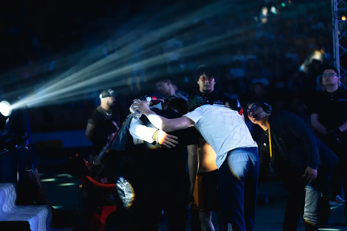 Group of people in an arena with dramatic lighting and spotlight effect.