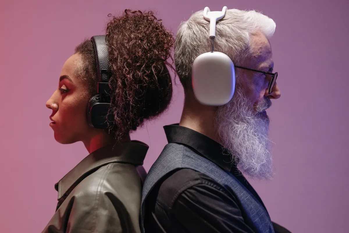 Creative studio shot of a black woman and a white man with headphones, showcasing diversity and technology.