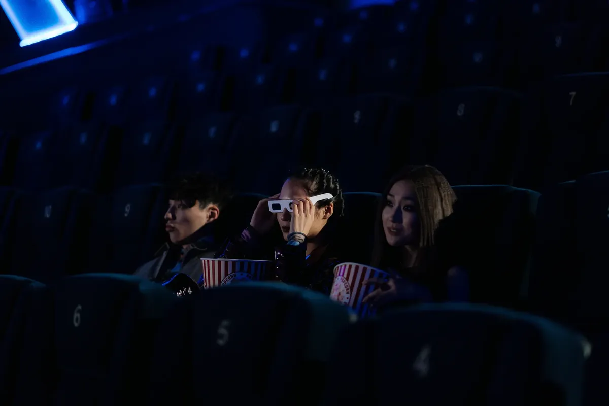 친구들이 어두운 실내 영화관에서 3D 영화를 보고 팬티를 즐기는 모습