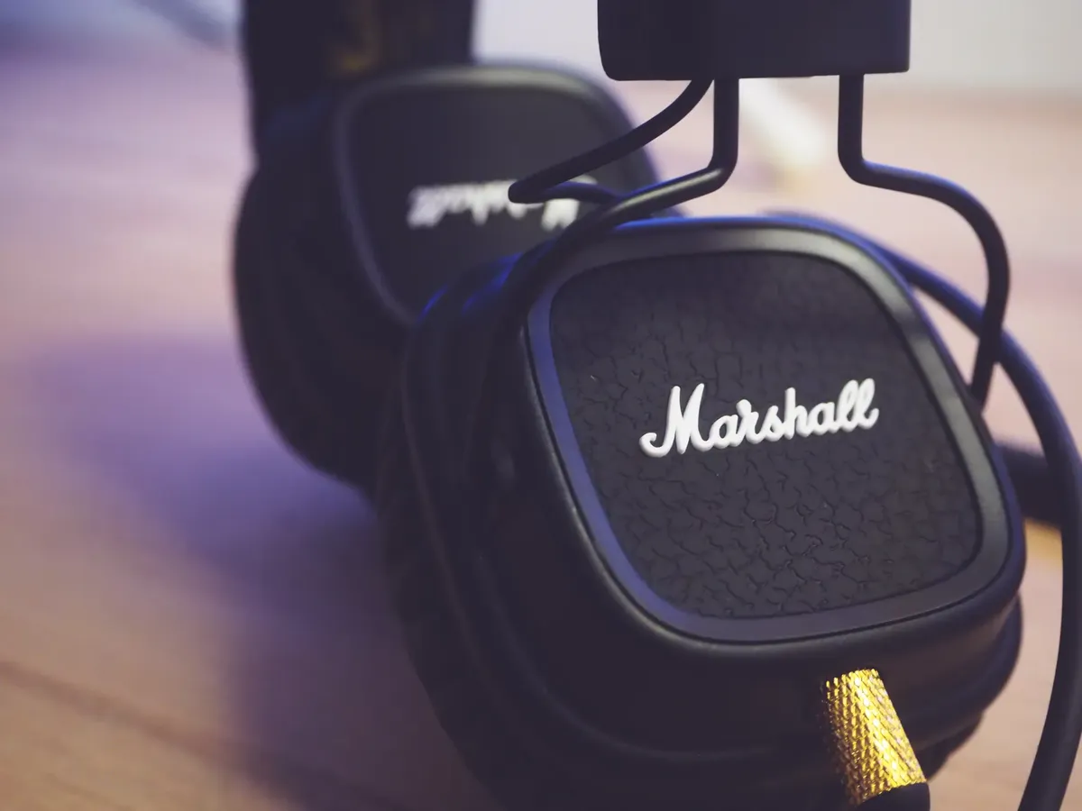 Detailed shot of high-quality modern headphones laying on a wooden surface indoors.
