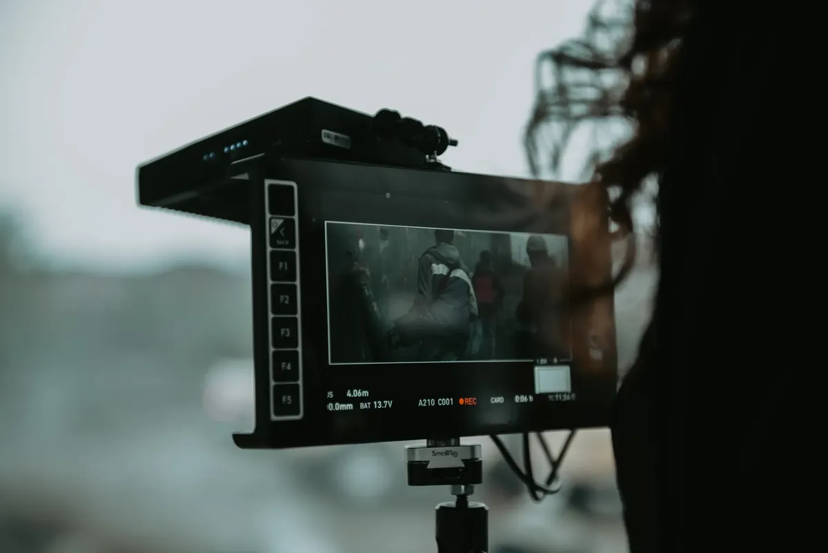 A close-up of professional filming equipment capturing a scene outdoors.