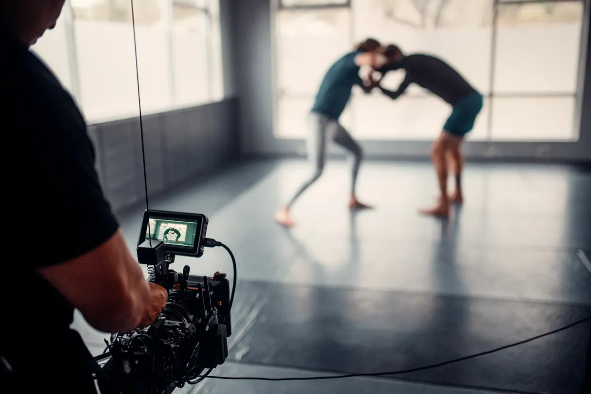 Capturing martial arts practice with professional filming equipment in a gym setting.