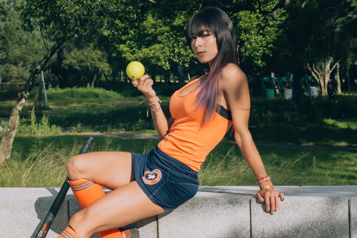 A fashionable woman in activewear poses outdoors with a ball, exuding elegance and style.
