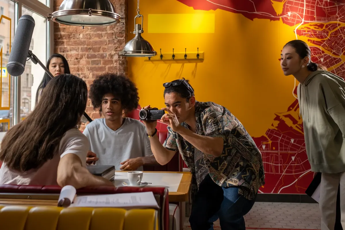A diverse film crew preparing for a creative scene in a trendy urban café.