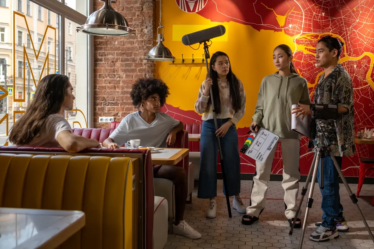 Film crew collaborating in a trendy urban cafe, capturing casual scenes.