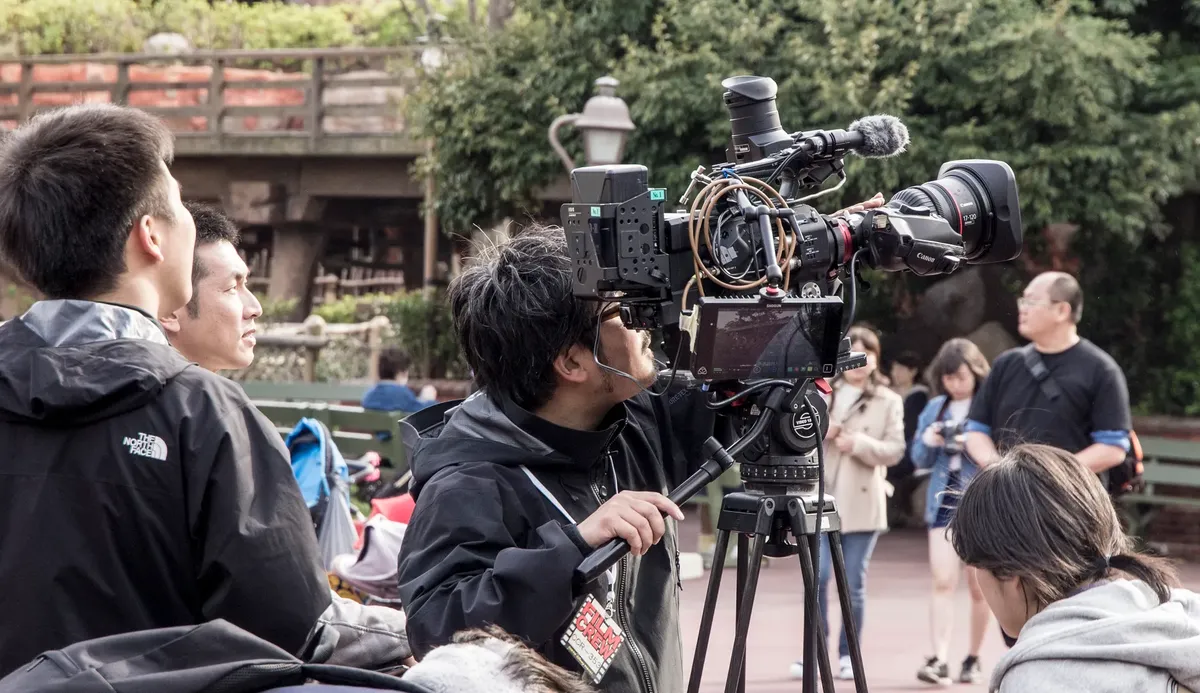 自然光の中で外場での映画スタッフが先進的なカメラ機材を使って撮影している様子。