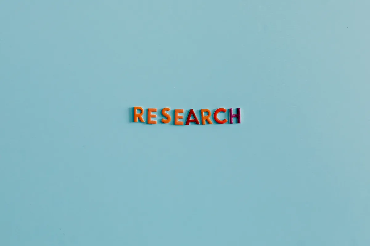 Colorful uppercase letters spelling 'RESEARCH' on a soft blue background. Ideal for education and science topics.