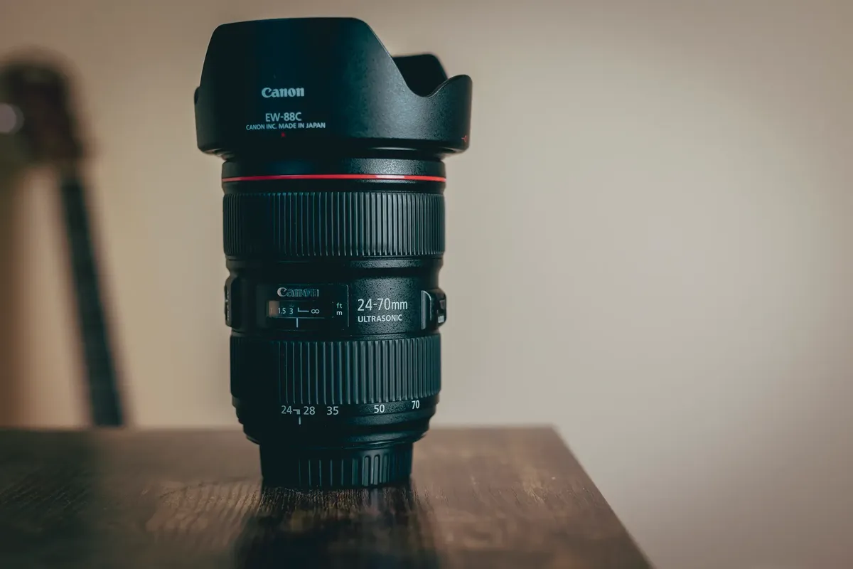 24-70mm 카메라 렌즈의 세부 이미지가 나무 테이블 위에 있습니다.