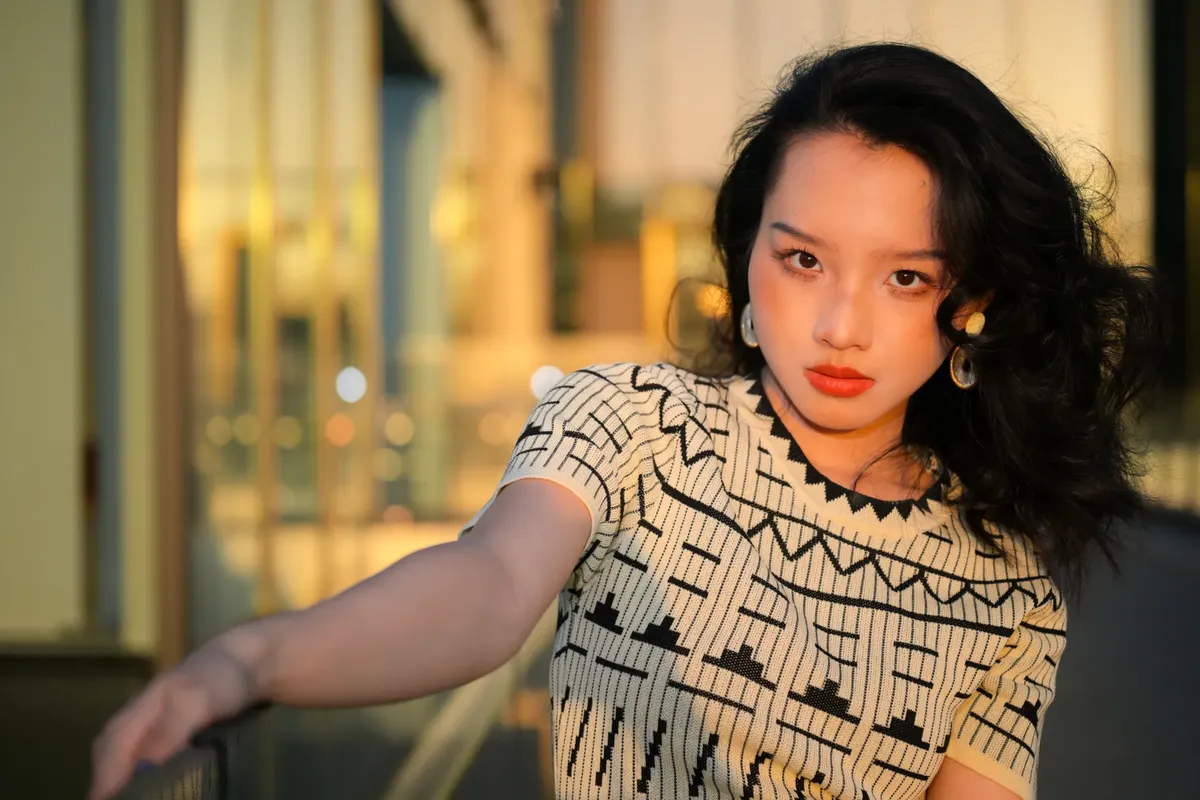 一名時尚年輕女子在都市地區 posing，伴隨著黃金時刻的照明，捕捉現代服裝與活潑情感。