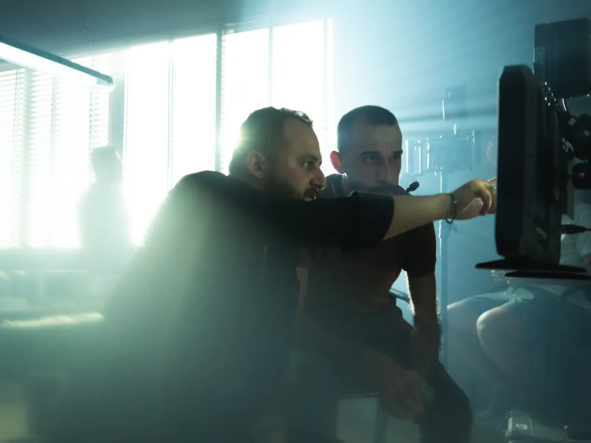 Film crew collaborating on set with cinematic lighting in Baghdad, Iraq, showcasing teamwork and creativity.