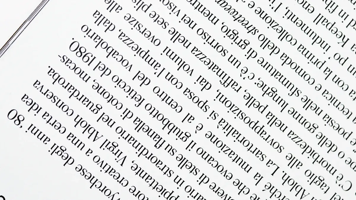Close-up view of upside down printed text on a white page, highlighting the font and arrangement.