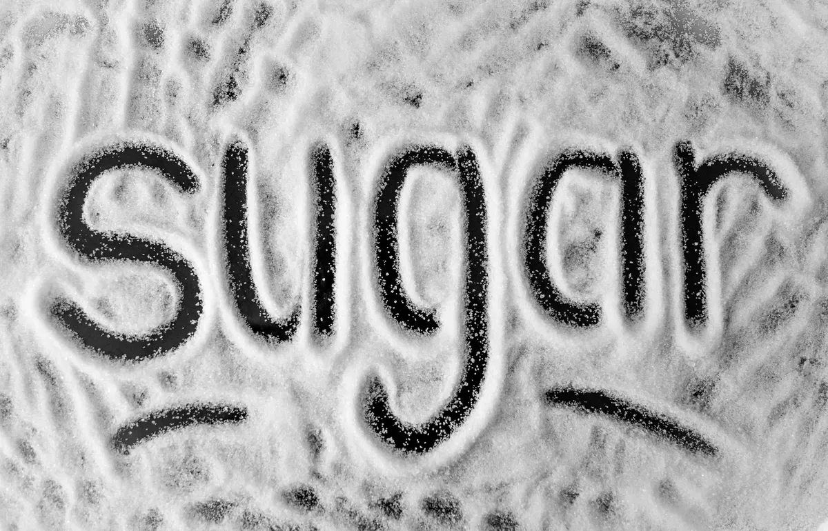 「sugar」以粉狀形式書寫，呈現甜點主題的極簡風照片。
